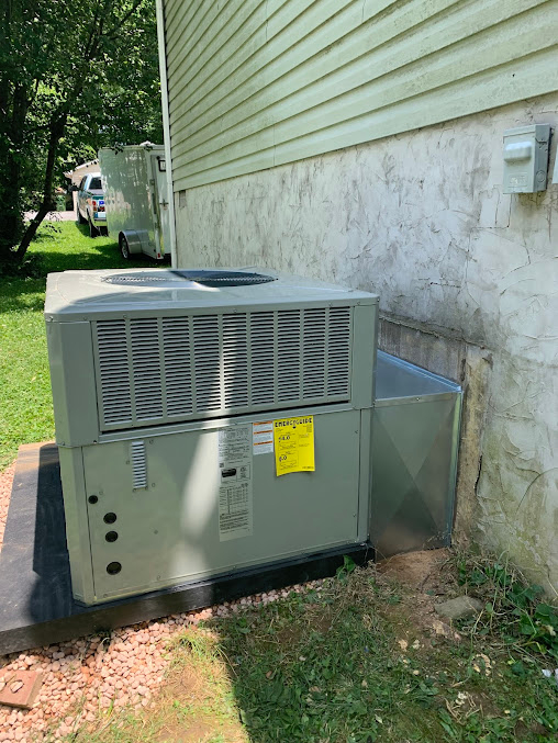 ThermoSTAT technician servicing air conditioning unit during summer projects