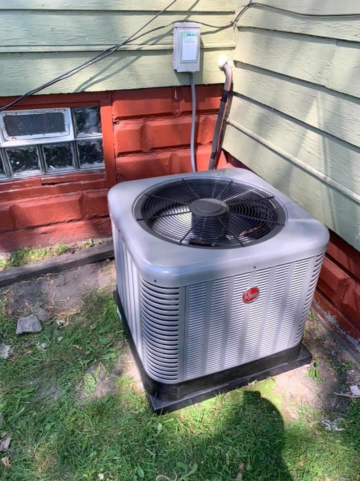 ThermoSTAT Heating & Cooling    technician servicing residential HVAC unit indoors