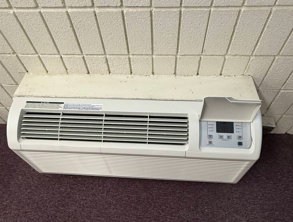 Technician from ThermoSTAT Heating & Cooling    servicing air conditioning unit on projects