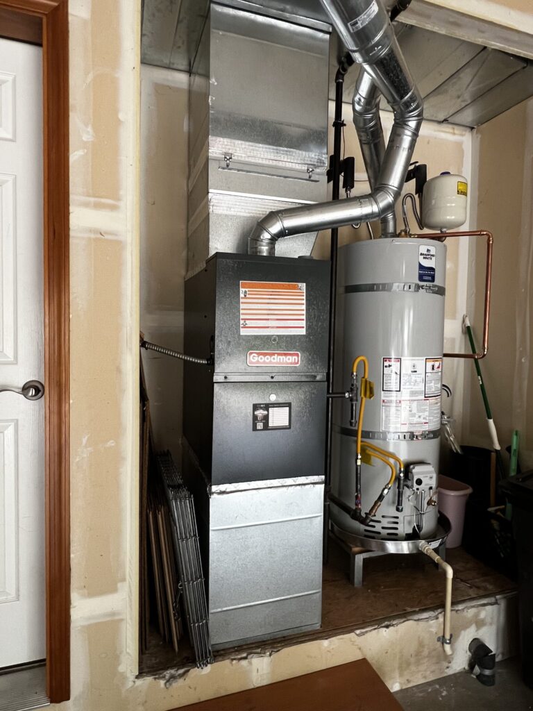 Professional ThermoSTAT technician repairing a reliable heating furnace in a suburban home basement