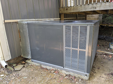 Technician from ThermoSTAT Heating & Cooling    servicing air conditioning unit during projects