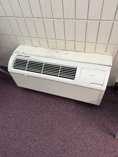 ThermoSTAT technician servicing residential furnace and AC unit in utility room