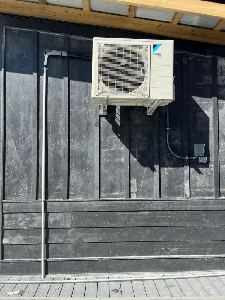 Technician installing ductless split system indoor unit for home heating and cooling