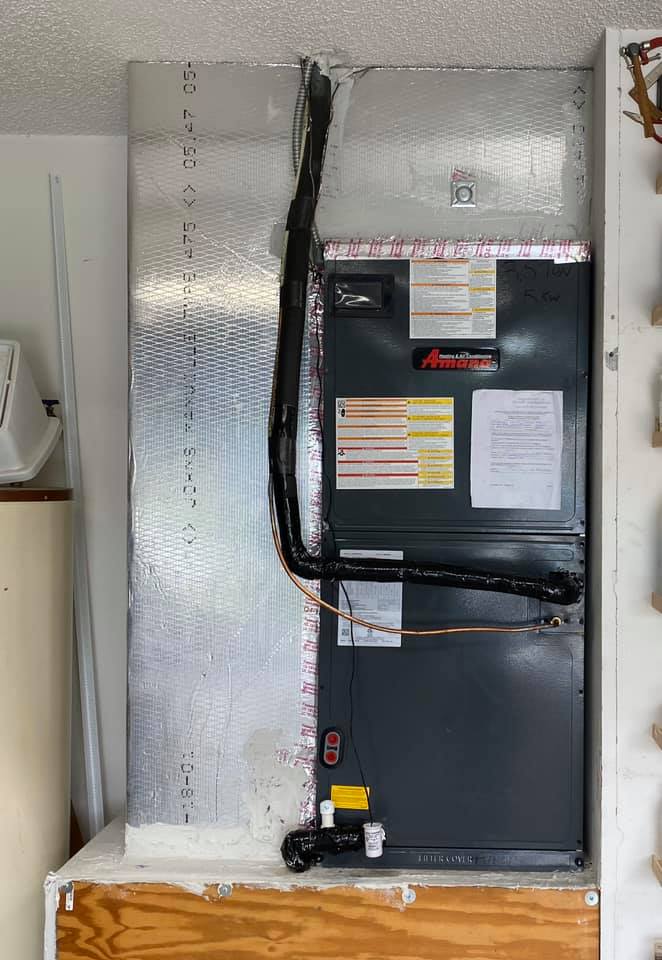 ThermoSTAT technician servicing a home furnace for reliable heating performance